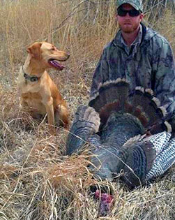 Rio Grande wild turkey hunting in New Mexico , hunter in tall grass with retriever (Photo by S.E. Morris)