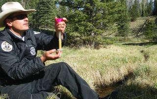 New Mexico Game and Fish  biologist measuring the volume of eggs collected from a female Rio Grande cutthroat trout.