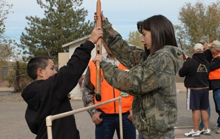 Students learning to safely cross a fence during a Hunter Education Course from New Mexico Department of Game and Fish.