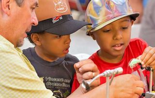 Become a Wildlife Conservation Volunteer. (Photo of fishing instructor helping youth). New Mexico Department of Game and Fish