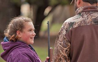 Become a Wildlife Conservation Volunteer. (Photo of hunting instructor helping youth). New Mexico Department of Game and Fish